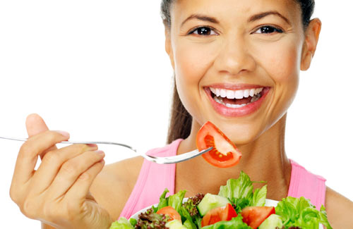 Glad kvinde der spiser sund salat